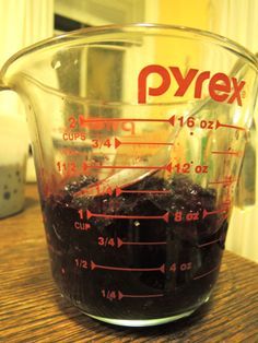 a measuring cup filled with liquid on top of a wooden table