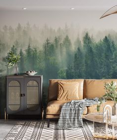 a living room with a couch and table in front of a forest mural on the wall