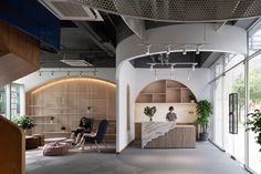 a person sitting at a desk in the middle of a room with lots of windows