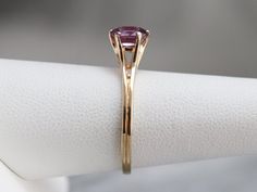 "Truly all about the stone, this elegant, simple, yellow gold mounting frames the stone perfectly while holding it securely. The gemstone pops with color, set with an expertly cut pink Ceylon sapphire. Set low to the finger, this would make a spectacular engagement ring, comfortable to wear with a variety of bands! Metal: 14K Yellow Gold Gem: Ceylon Pink Sapphire 1.02 Carats Gem Measurements: 6.6 x 5.7 mm, Oval Ring Size: 7 Marks: \"14K BDW\" Stamped on the inside band SKU #: UUHQRF82 Each piece Yellow Gold Cushion Cut Amethyst Ring, Cushion Cut Yellow Gold Amethyst Ring, Modern Yellow Gold Birthstone Ring With Center Stone, Elegant Yellow Gold Amethyst Ring With Bezel Setting, Classic Gold Amethyst Solitaire Ring, Elegant Yellow Gold Sapphire Ring With Tension Setting, Classic Yellow Gold Amethyst Birthstone Ring, Elegant Yellow Gold Amethyst Ring With Round Band, Classic Yellow Gold Amethyst Ring With Prong Setting