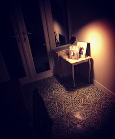 a small table with pictures on it next to a door and window in a dark room