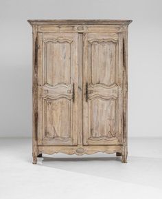 an old wooden armoire with two doors and carvings on the front, sitting against a white background