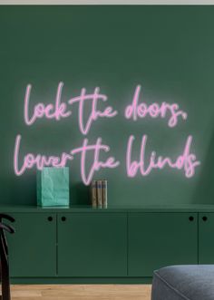 a neon sign that reads look the doors, lower the blinds on a green wall