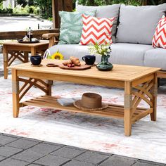 a wooden table sitting on top of a white rug next to a couch and coffee table