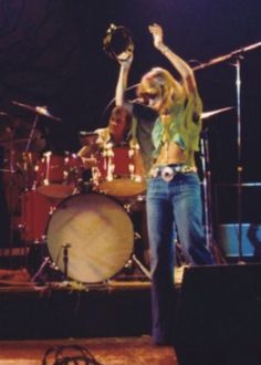 a woman on stage with her arms in the air