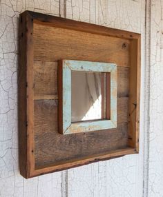 a wooden frame mounted to the side of a wall with a mirror on top of it