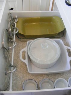 an open drawer with pots and pans in it on the bottom right hand corner