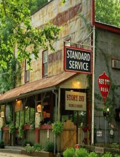 an old building with a stop sign in front of it that says standard service on the outside