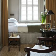 a bed sitting next to a window in a bedroom