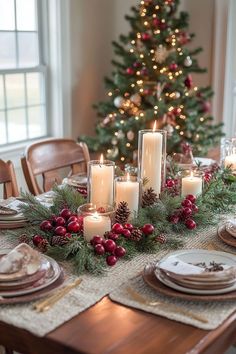 a christmas table setting with candles and plates