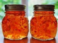 two jars filled with jam sitting on top of a table