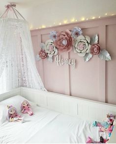 a white bed with pink flowers on the headboard and name sign above it that says honey