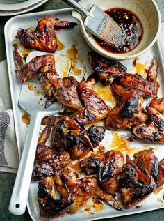 chicken wings on a tray with sauce in a bowl