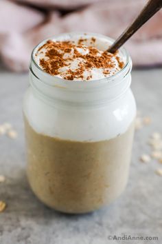 a glass jar filled with whipped cream and cinnamon sprinkles on top of a table