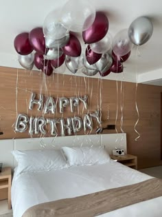 balloons are hanging from the ceiling above a bed