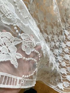 This is a white net, white fabric embroidered with intricate floral motifs from one corner to another. The embroidery is done very neatly so that this can also be used from the backside. There is an embroidered ladder motif on both long edges.  This would make a gorgeous chuppah canopy as it looks like a canopy made from flowers. The embroidery on the net fabric shows on the reverse and front sides.  MATERIAL = soft net, but intricate embroidery adds texture and weight to the fabric.  USAGE = We White Embroidered Fabric With Lace Trim, White Embroidered Fitted Fabric With Lace Trim, Fitted White Embroidered Fabric With Lace Trim, White Lace Embroidered Fabric For Spring, White Embroidered Lace Fabric, White Lace Embroidered Fabric, Traditional White Lace With Intricate Embroidery, Spring White Embroidered Fabric With Lace Work, Spring White Embroidered Lace Fabric