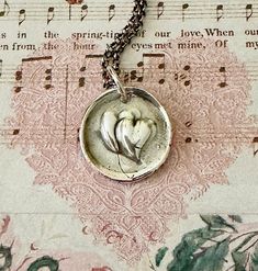 a close up of a necklace on a piece of paper with music notes in the background