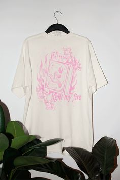 Light your fire in this band tee inspired vintage wash oversized tee that can be worn all year around but is perfect for Valentines Day!- Features the phrase "baby light my fire" with baby repeating throughout & a matchbox with a hand and heart on it, all in a pink ink- Screen print transfer that is heat pressed onto each tshirt- Tshirt is a super soft vintage wash that gets softer after each wash- Oversized fit- Sizing translation: XS/S = L , S/M = XL , L/XL = 2XL , 2XL/3XL = 3XL- Size up if yo Screen Print T Shirt Design, Heart Graphic Tee, Screen Print Tshirt, Vintage Tshirt Design, Pink Graphic Tee, Baby Light, Screen Print Transfer, Fire Designs, Tshirt Design Inspiration