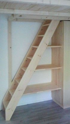 an empty room with a ladder to the ceiling and shelves on the wall next to it