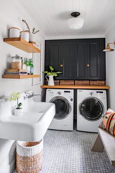 a washer and dryer in a small room with shelves above the washer