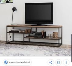 a flat screen tv sitting on top of a wooden shelf