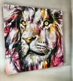 a painting of a lion with yellow eyes is hanging on the wall in a room