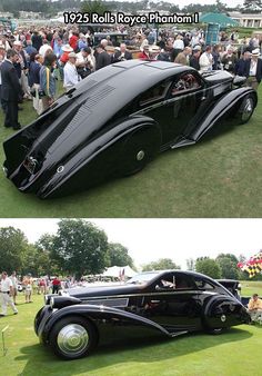 an old black car parked on top of a lush green field next to a crowd of people