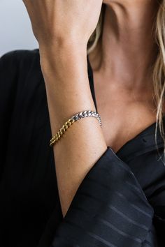 Featuring a striking blend of gold and silver, the mixed metal cuban link chain bracelet creates a bold and contemporary look. Its durable construction and eye-catching design make it the perfect statement piece to elevate any outfit.- Stainless steel base - Length: 7" / 177.8mm (one size fits most) - Width: 0.24" / 6mm- Lobster clasp- Available in mixed-metal- Engraved with signature MC branding- Hypoallergenic, non-tarnish, water-resistant Modern Chunky Chain Cuban Link Bracelets, Modern Bracelets With Chunky Cuban Link Chain, Modern Chunky Cuban Link Chain Bracelet, Modern Metal Cuban Link Chain Bracelet, Modern Cuban Link Bracelet With Chunky Chain, Modern Chunky Cuban Link Bracelet, Modern Chunky Chain Cuban Link Bracelet, Modern Cuban Link Chain Bracelet, Modern Cuban Link Curb Chain Bracelet