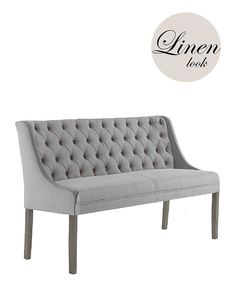 a gray couch sitting on top of a wooden floor next to a white sign that says linen books