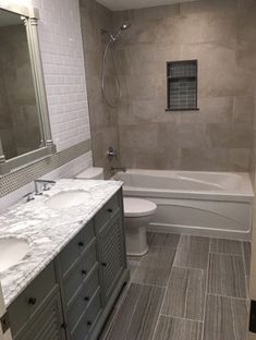 a bathroom with two sinks, a toilet and a bathtub