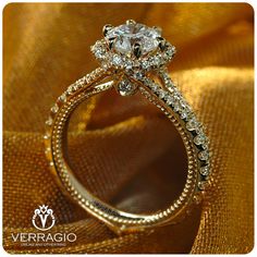 an elegant diamond ring on top of a gold cloth with the words veragio written below it