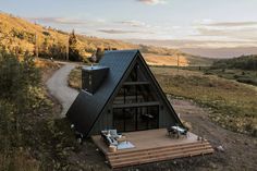 a small cabin sits on the side of a hill