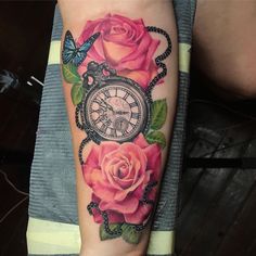 a woman's arm with roses and an alarm clock on the inside of it