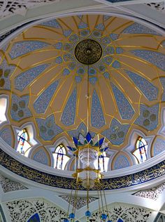 the inside of a building with stained glass windows and a chandelier hanging from it's ceiling