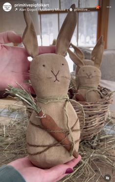 two stuffed rabbits sitting on top of hay