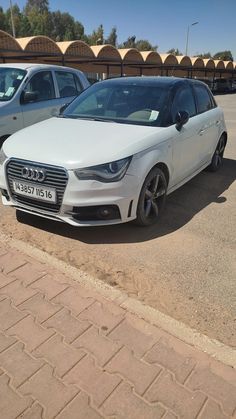 a white car parked in a parking lot next to other cars