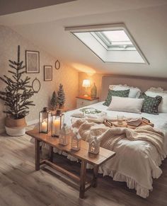 a room with a bed, coffee table and candles on it in front of a skylight