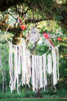 an image of a dream catcher hanging from a tree with flowers and leaves on it