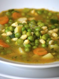 a white bowl filled with peas and carrots