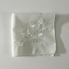 Vintage Shiny White Embroidered Flower Handkerchief Perfect for a wedding or a keepsake. In good vintage condition. This has been washed with OxyClean and Woolite. This is a vintage handkerchief, it may have minimal signs of wear. There may be tiny or small holes from the age of the delicate material. Please see photos for noticable signs of wear that I can see.  Approximate Size: 9 3/4" x 10" White Embroidered Flower Shaped Handkerchiefs, White Embroidered Flower-shaped Handkerchiefs, Elegant White Handkerchiefs With Floral Embroidery, Elegant White Floral Embroidered Handkerchiefs, Vintage Floral Embroidery Wedding Handkerchiefs, White Flower-shaped Handkerchiefs As Gift, Vintage Wedding Handkerchiefs With Machine Embroidery, Vintage Embroidered Handkerchiefs For Wedding Gift, Flower Handkerchief