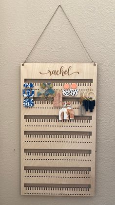 a wooden sign hanging on the side of a wall with pins and magnets attached to it