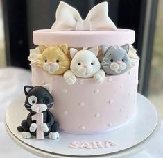 a pink cake decorated with cats and kittens