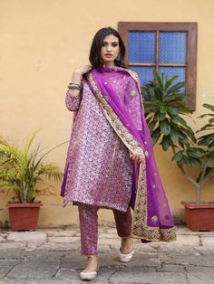 With festivals around the corner, wardrobe update is mandatory. Presenting brocades like never before. Made in straight silhouette with narrow pants and organza dupatta, which is beautified with lovely hand work. Taari and gotta detailing on dupatta is just the right touch. Color: Purple Fabric: Kurta & Bottom- Brocade Dupatta - Organza Note: Length and sizes can be customised Length - Kurta 40 inches Pants 38 inches Available in other colors If you happen to see some deformity in hand-work or f Brocade Suits Indian, Banarsi Suit, Brocade Dupatta, Brocade Kurta, Brocade Suits, Corner Wardrobe, Purple Suits, Purple Hands, Wardrobe Update