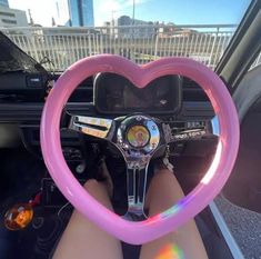 a person is sitting in a car with a heart shaped steering wheel cover over their head