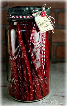 a jar filled with red candles sitting on top of a table