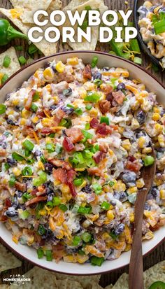 a bowl filled with corn salad next to tortilla chips