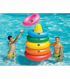 two young men playing in the pool with an inflatable stacking ring toy