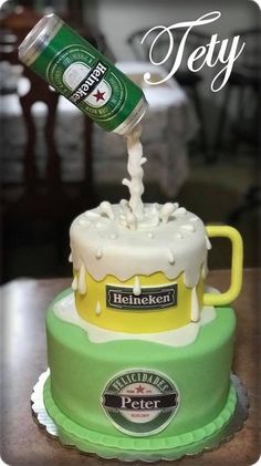 there is a beer being poured on top of a cake that has been decorated with frosting