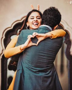 a man and woman hugging each other in front of a mirror with their arms around each other