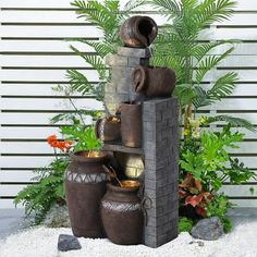 an outdoor fountain with pots and plants surrounding it